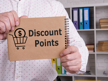 A man holding a book discussing FHA mortgage discount points and their impact on mortgage rates.
