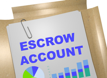 A clipboard with the word escrow account on it, highlighting monthly mortgage payment.