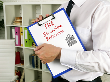 A man holding a clipboard with the words FHA streamline refinance program.