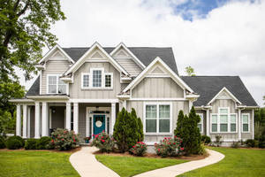 A charming home with a driveway leading up to the welcoming front door, surrounded by greenery.  