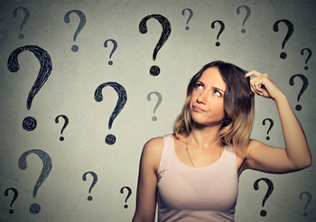 A woman with lots of question marks about FHA loans on a wall behind her